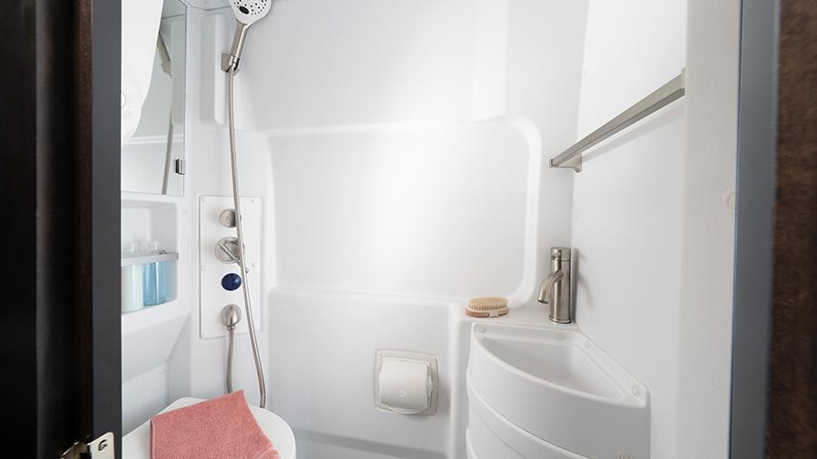 Expanse 21B Wet Bath | The Expanse 21B wet bath features a shower with magnetic curtain surround, Aqua View® SHOWERMI$ER water management system, a toilet with foot flush, a medicine cabinet with a mirror and a powered roof vent.