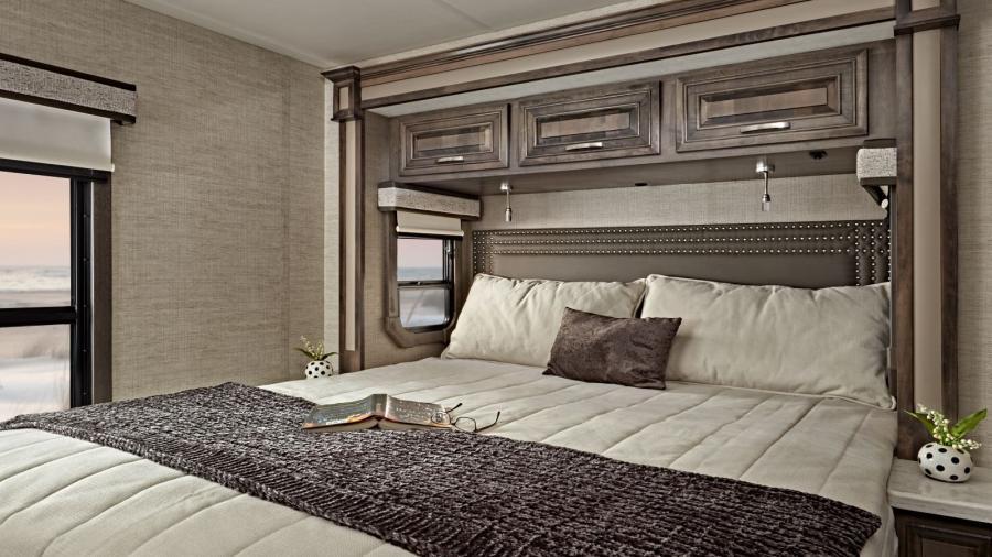 A restful oasis, the 2023 Accolade bedroom has a walk-around, king size bed with power head lift, bedspread and nightstands, USB port and wireless charging in the nightstands, under-bed storage (select models), LED HD Smart TV and large wardrobes.
