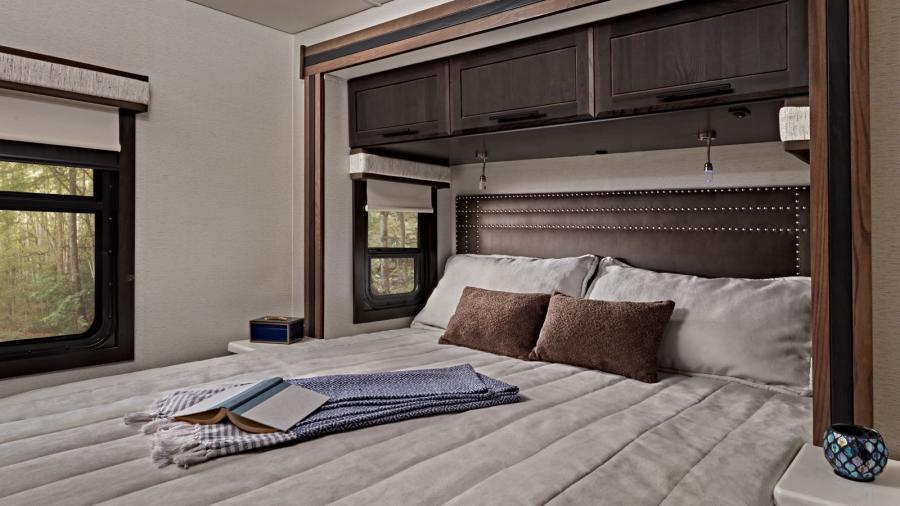 Accolade XT 35L Bedroom | Retreat to the walk-around, king size bed with bedspread and nightstands in the Accolade XT 35L where you’ll also find more storage, reading lights and a residential-style headboard. 