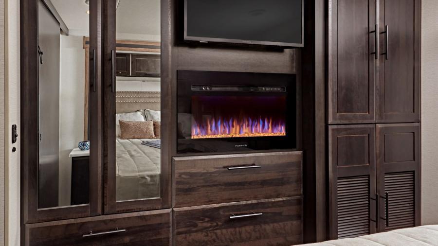 Accolade XT 35L Wardrobe | The large wardrobes in the Accolade XT 35L have a warm feel, literally, thanks to the Furrion electric fireplace and an LED HD Smart TV. 