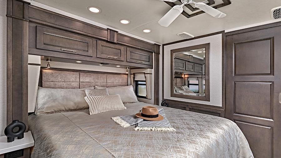 Aspire 44R Bedroom | Unwind in the Aspire 44R bedroom with a king size gel memory-foam mattress, a residential-style headboard, a ceiling fan and nightstands with solid-surface tops. There is overhead storage and reading lights for your convenience. 
