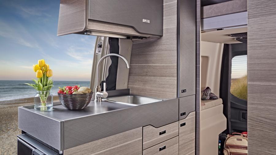 Enjoy cooking in the Launch with its three cubic foot DC refrigerator, portable induction cooktop, stainless-steel sink and Tecnoform pull-out kitchen countertop extension. With the screen retracted, enjoy preparing meals in the open air.