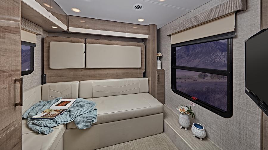 The 2023 Qwest features an 80-inch high padded vinyl ceiling, high-intensity LED ceiling lights, high-gloss hardwood fascia and Tecnoform high-gloss cabinetry. This hangout space features premium furniture to relax and watch the LED HD TV. (24N Shown)