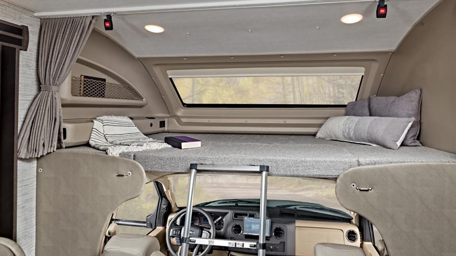 Odyssey 24B Overhead Bunk | The overhead bunk in the Odyssey 24B has a 750 lb. weight capacity. Enjoy the view out of the automotive-bonded panoramic window with a power shade. Easily access the bunk with the removable ladder.