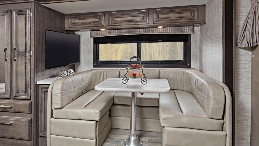 Odyssey 24B U-shaped Dinette | The U-shaped dinette in the Odyssey 24B has space for everyone to sit down and enjoy a meal. It’s also a great space to sit and watch the LED HD Smart TV.