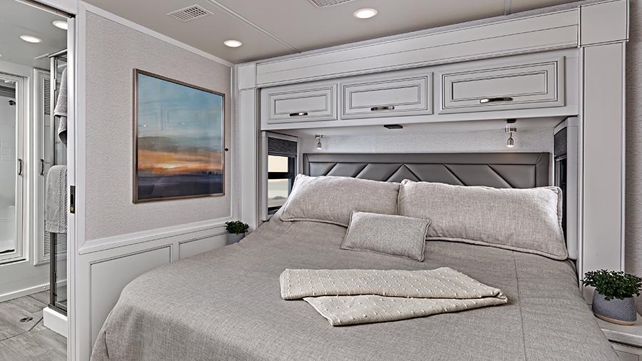 Reatta XL 40Q3 Bedroom | Unwind in the Reatta XL 40Q3 bedroom with king size pillow-top mattress on a tilt bed, nightstands, overhead storage, a residential-style headboard and reading lights.